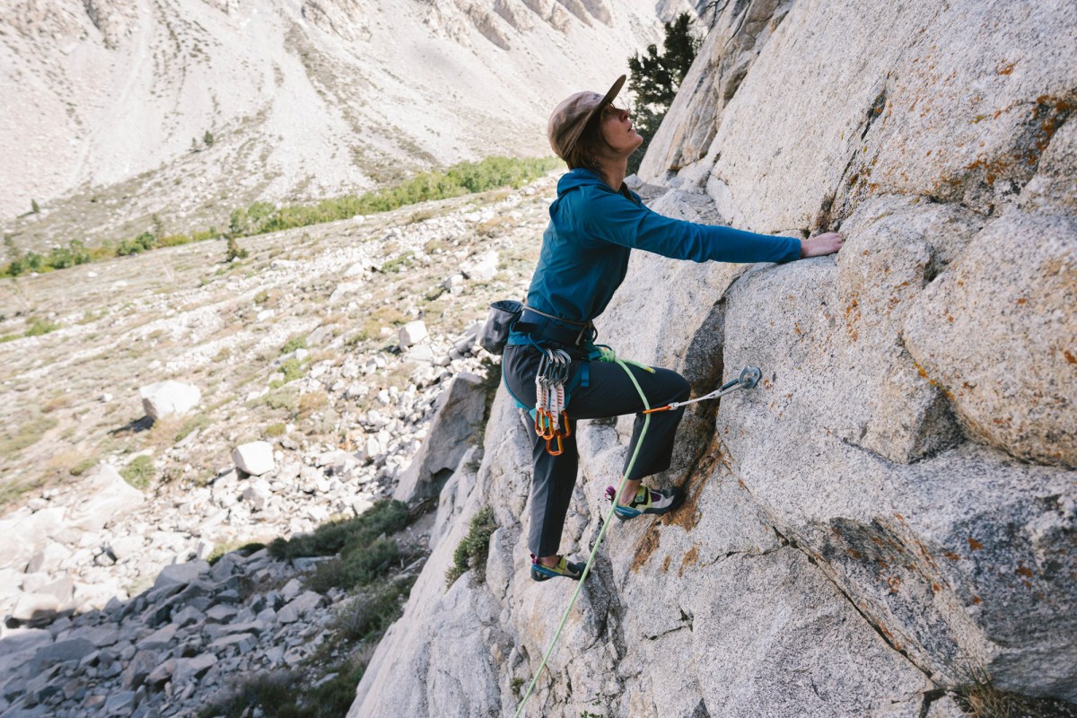 Climber wearing Sequence Pants ascends a granite wall