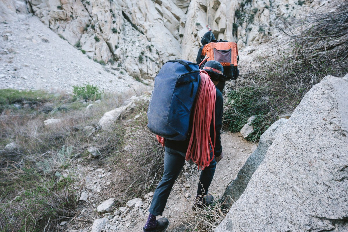 Climber hiking through a rocky canyon with the rope over one shoulder