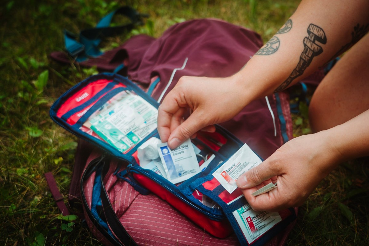 Hiker selecting wound care items from the HART Outdoor Weekend First Aid Kit