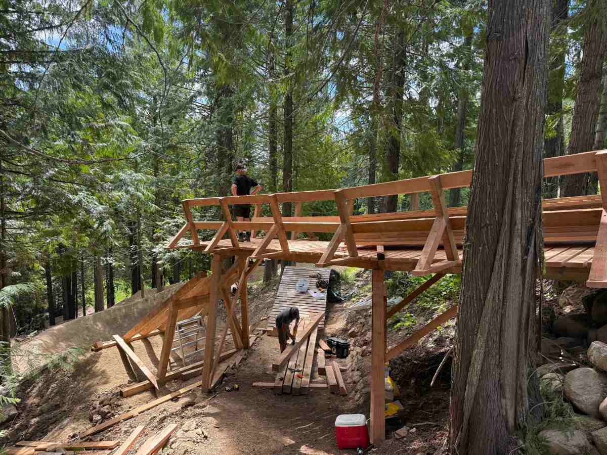 GL project manager Dane Tudor waiting for wood craftsman Dave Satanove to hand up materials while building the entrance to Obsidius at RED Bike Park; (photo/Morgan Tilton)