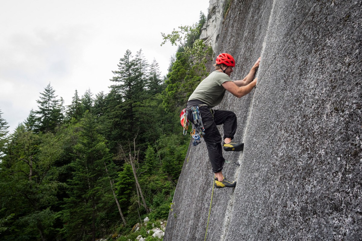 Climber ascending a granite slab with a Mammut dry climbing rope