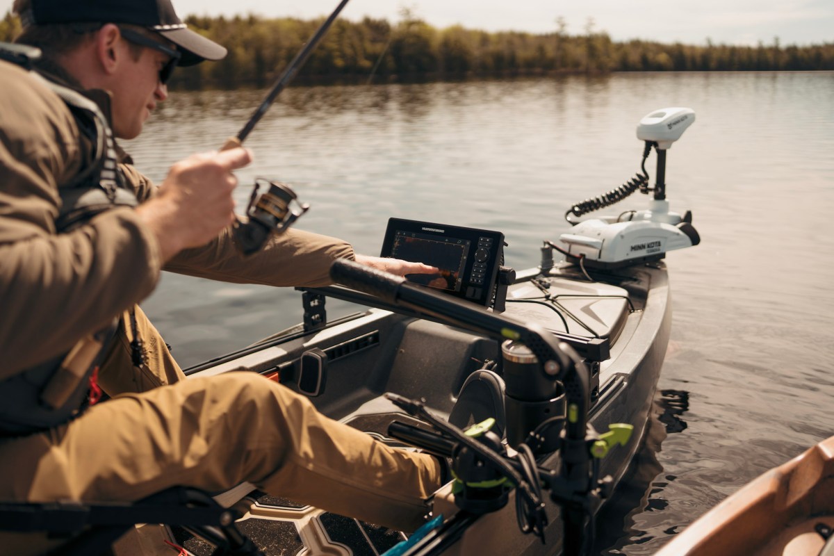 A kayak angler using a fish finder on the water.