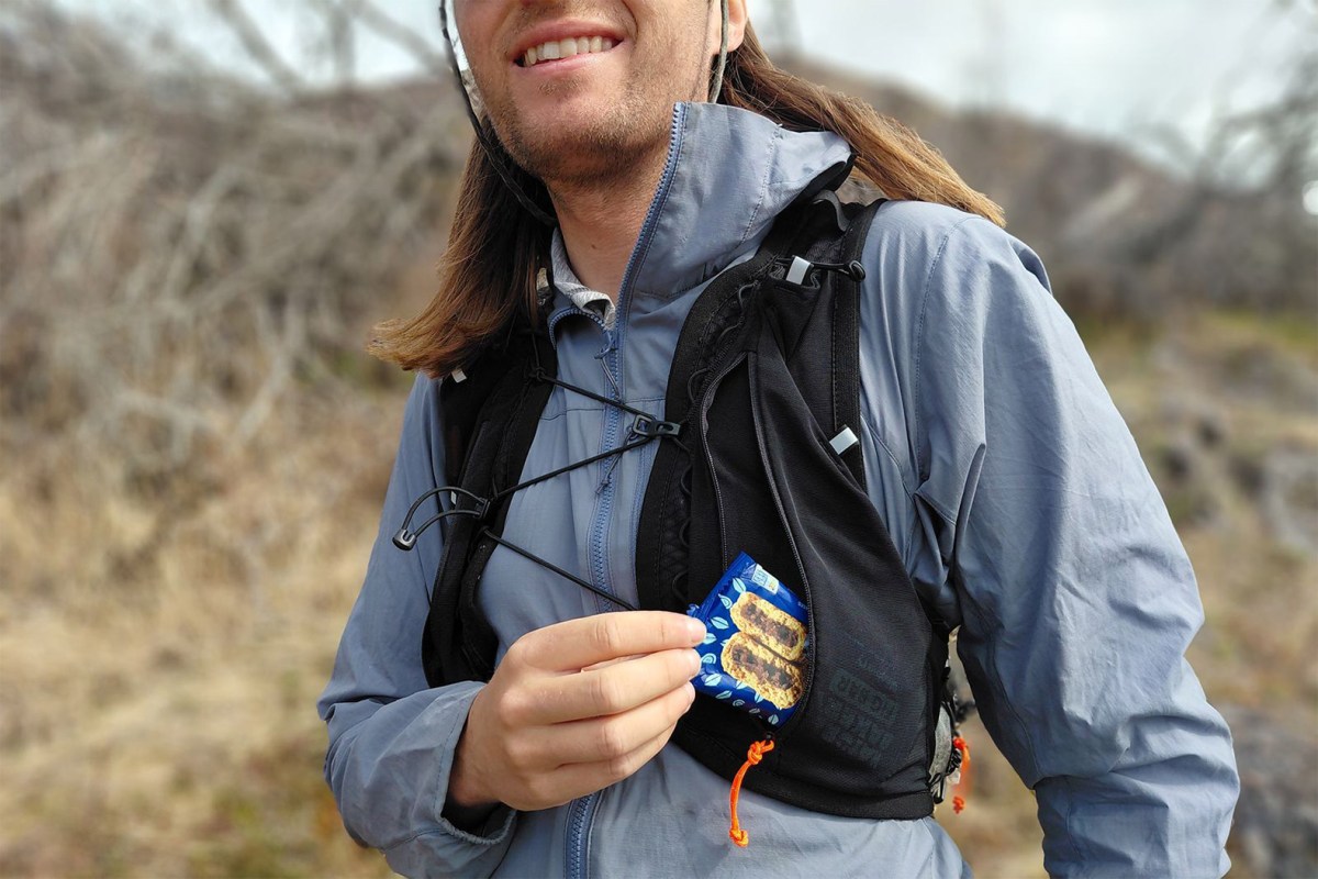 Hiker pulling a snack from the front pocket of the Pemi 15