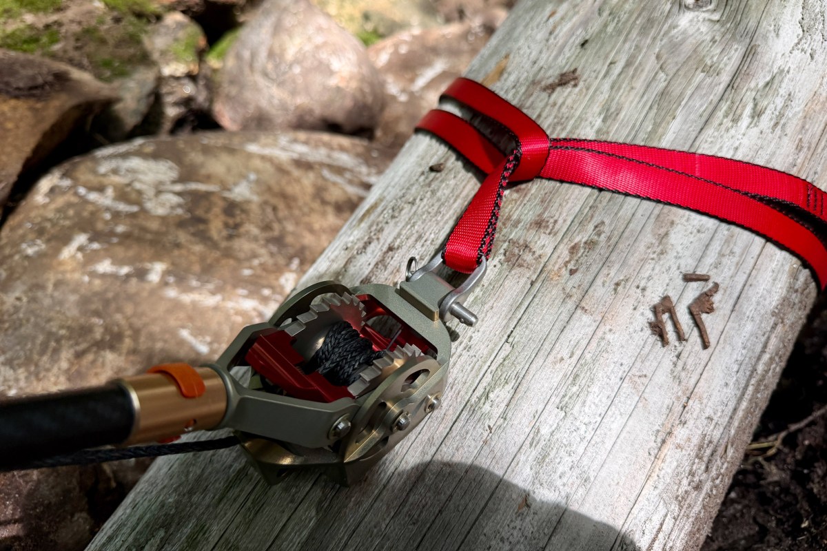 Pocket winch strapped to a fallen log over a rocky creek
