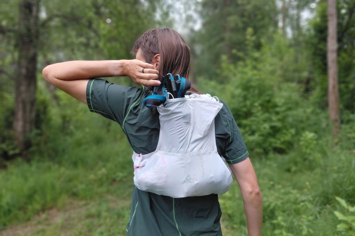 Rear view of the white Raide Research vest carrying climbing gear in its back pocket