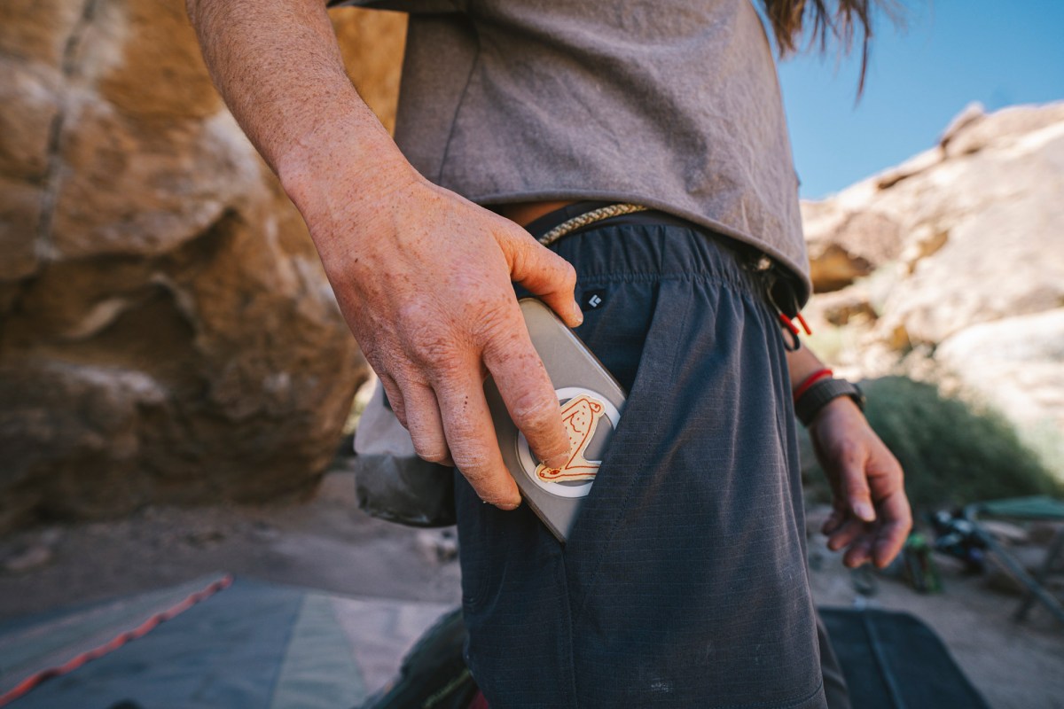 Climber slides a phone into the Sequence Pants side pocket