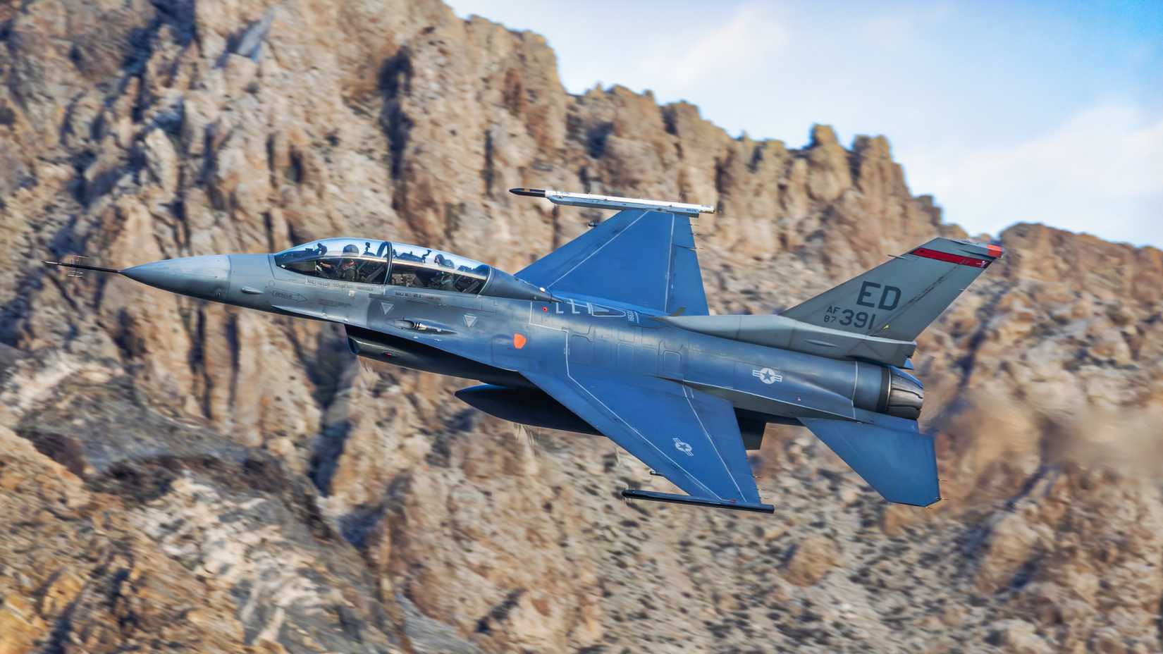 A U.S. Air Force F-16D from Edwards Air Force Base flies low through a rocky canyon during Louis Skupien’s documentary flight.