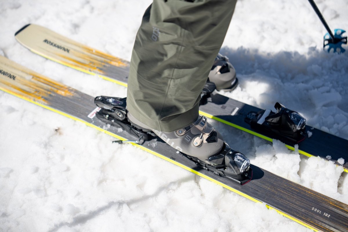 Close-up of grey Dalbello ski boots clipped into Rossignol Soul 102 skis.
