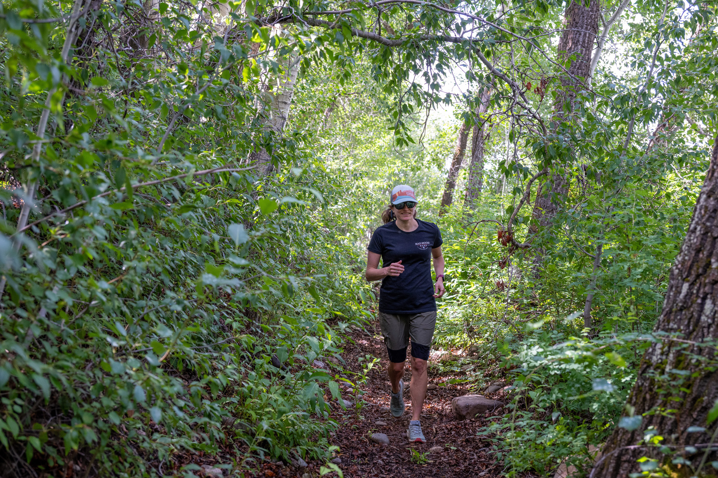 A woman trail running through the forest