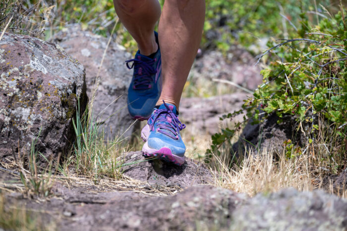 Close up of trail running shoes on a rocky path