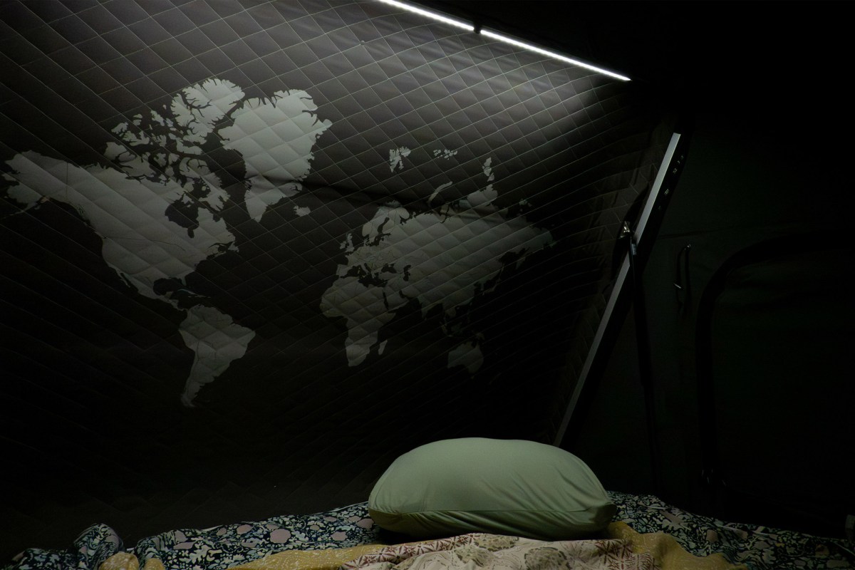 Illuminated Skycamp 4.0 Trio interior with bedding and a world map panel