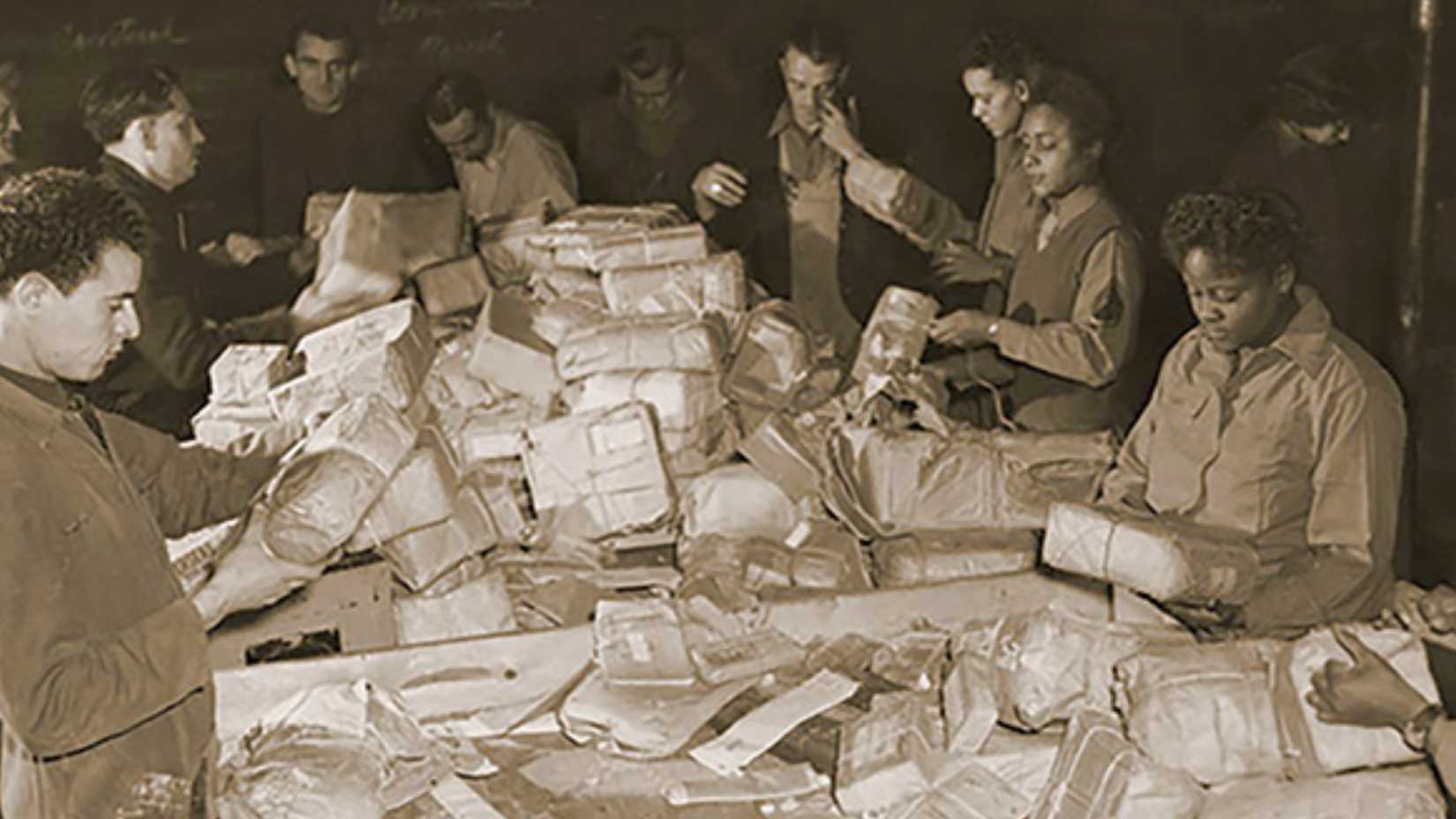 Members of the 6888th Central Postal Directory Battalion and French civilians sort packages in Paris in 1945.