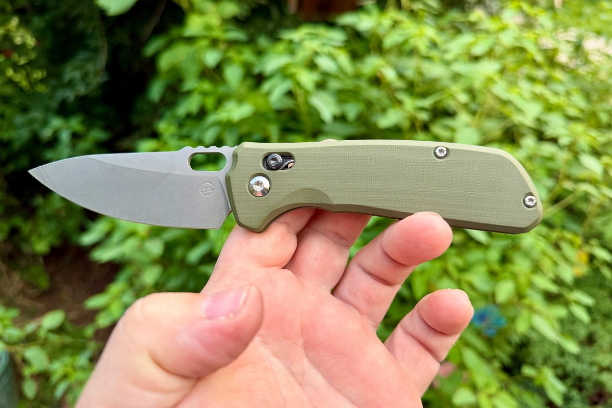 Open Schwarz Enduro with green handle held outdoors against leafy background