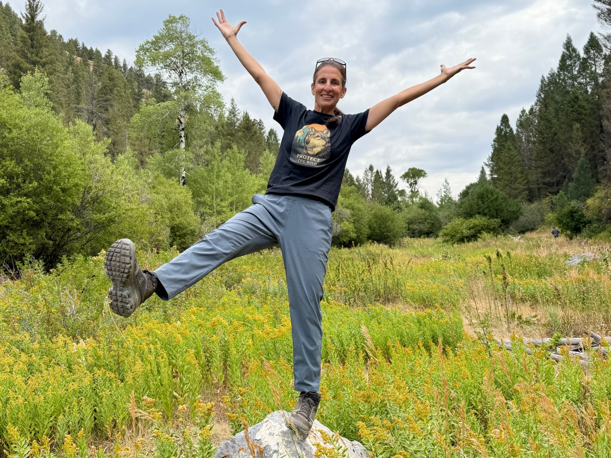 Woman testing the Mountain Hardwear Dynama Ankle Pants and the On Cloudrock Waterproof hiking boots on a hike involving rock scrambling and creek crossing.