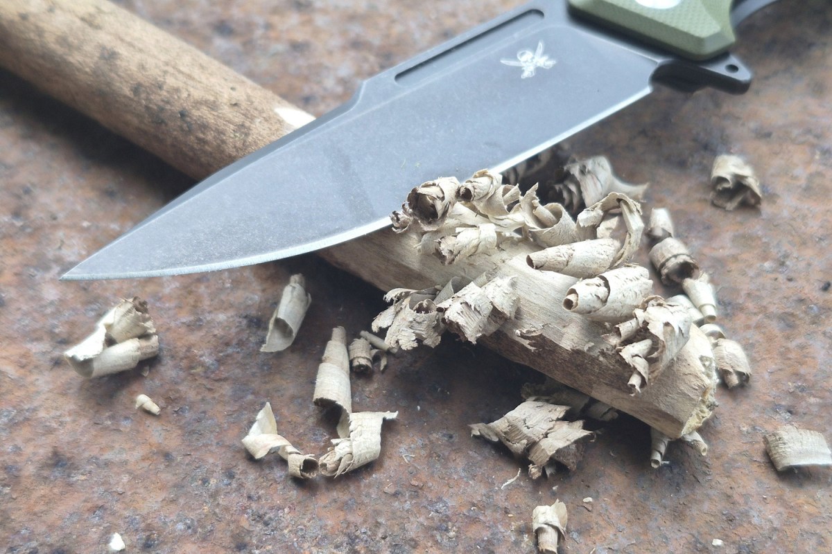 Iron Jaw knife blade surrounded by fresh wood shaving