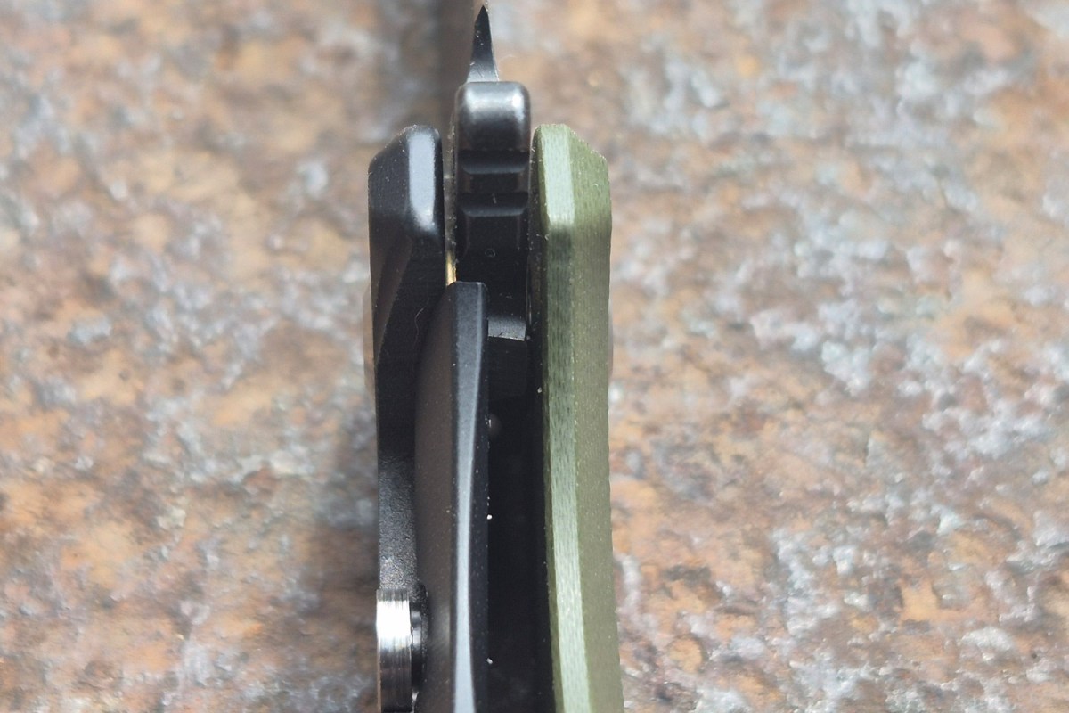 Close-up of the Iron Jaw knife spine, pocket clip, and green handle