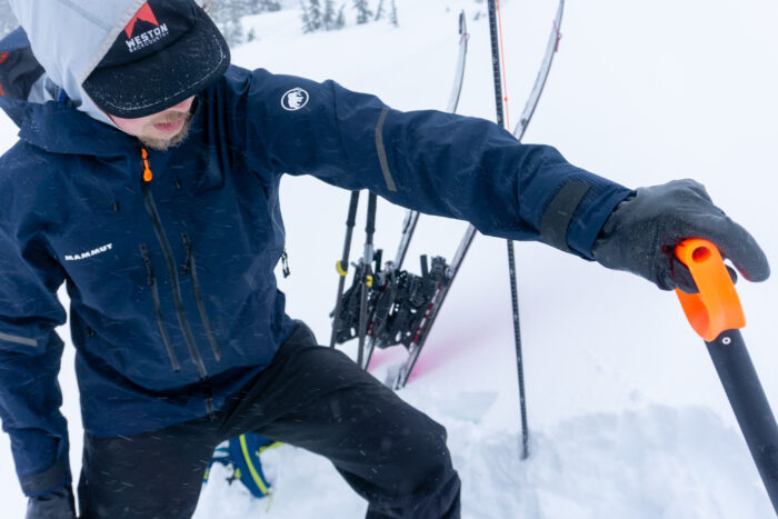 a gearjunkie tester wearing the mammut nordwand hs hardshell shovels snow in washington state