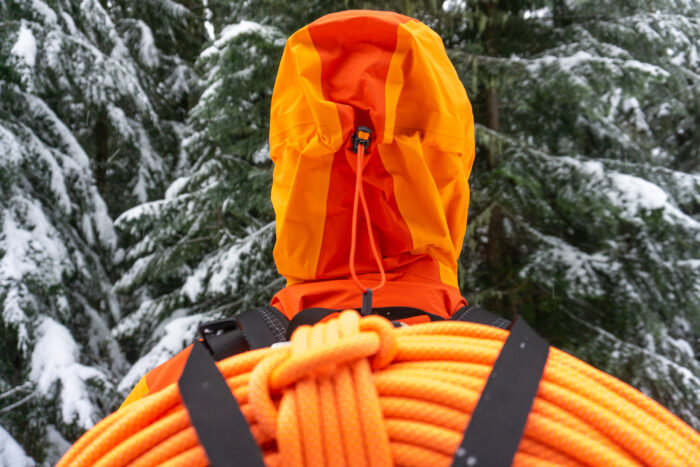 a gearjunkie tester wearing the orange Norrona Trollvegen Pro Light with view from behind looking at the hood design
