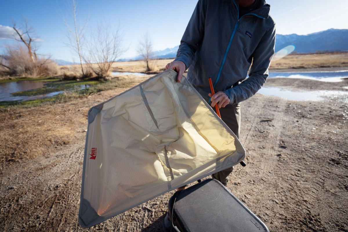 a gearjunkie tester assembles the rei co-op flexlite air chair by attaching the frame system to the fabric sling
