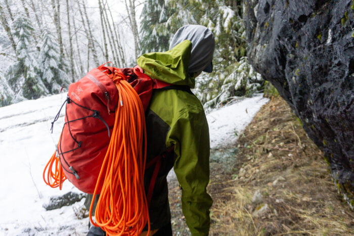 the author wearing a rab latok mountain hardshell jacket while hiking into a drytooling crag in washington state