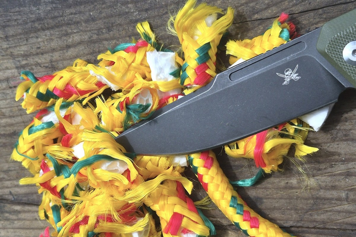 Skallywag Tactical knife blade beside cut sections of braided rope
