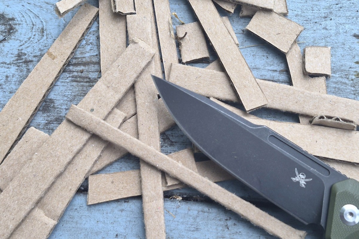 Skallywag knife blade surrounded by cut strips of cardboard