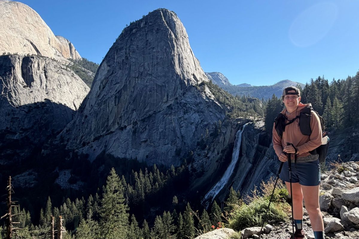 hiker stands in front of vista of waterfall