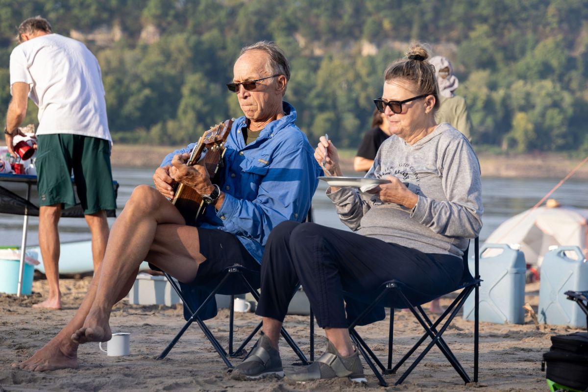 two people sit in chairs on a beach