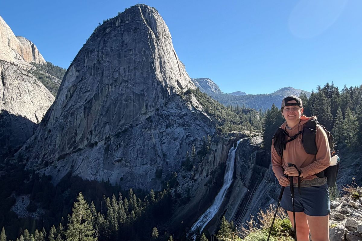 hiker stands next to waterfall