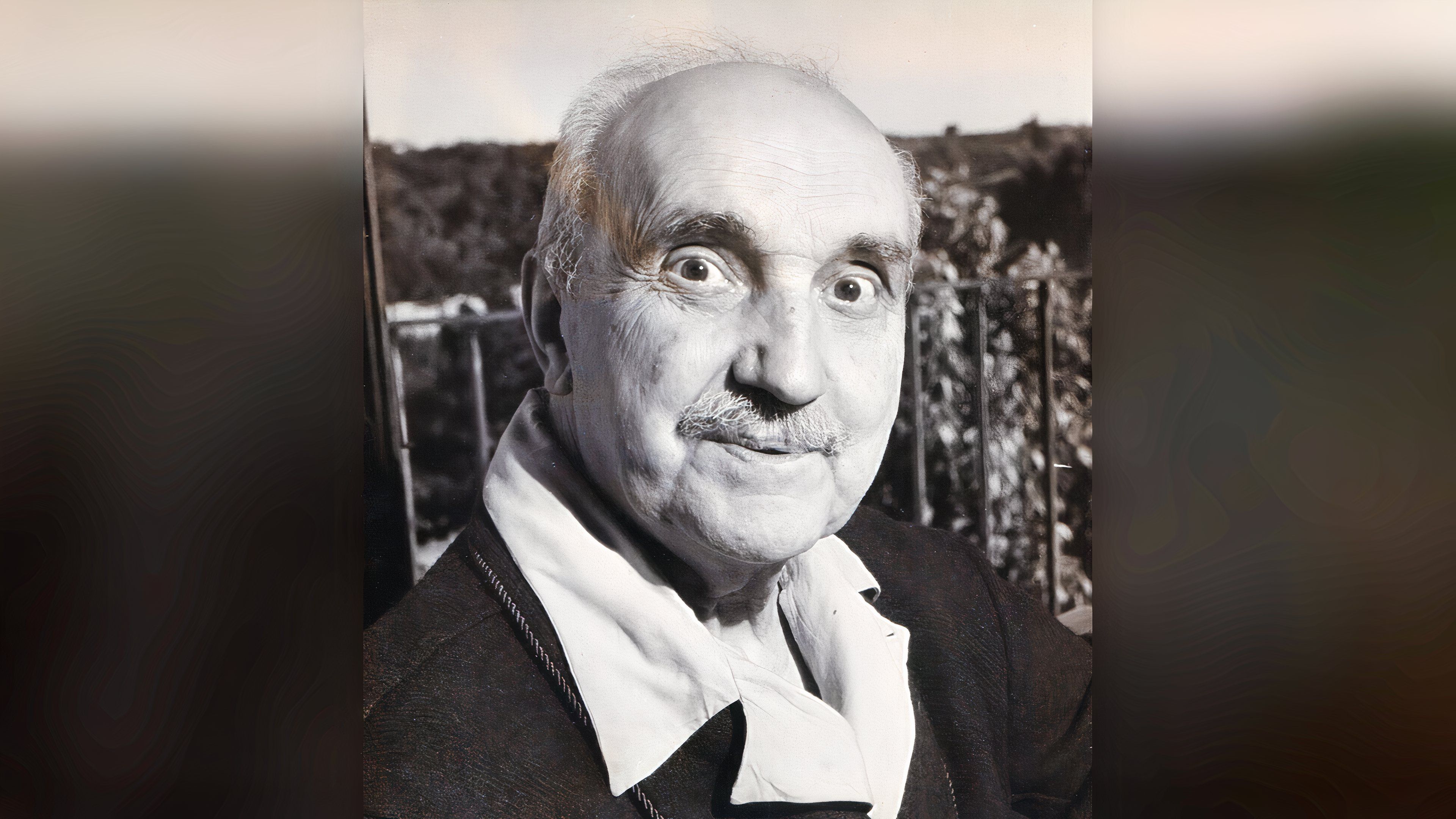 A black-and-white portrait of philosopher George Santayana seated outdoors at Santo Stefano Rotondo Convent in Rome in 1947.