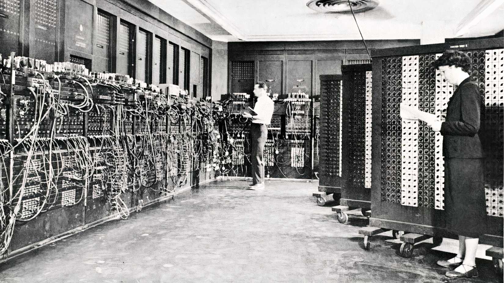 Glen Beck and Betty Snyder work beside the wires and control panels of the ENIAC computer.