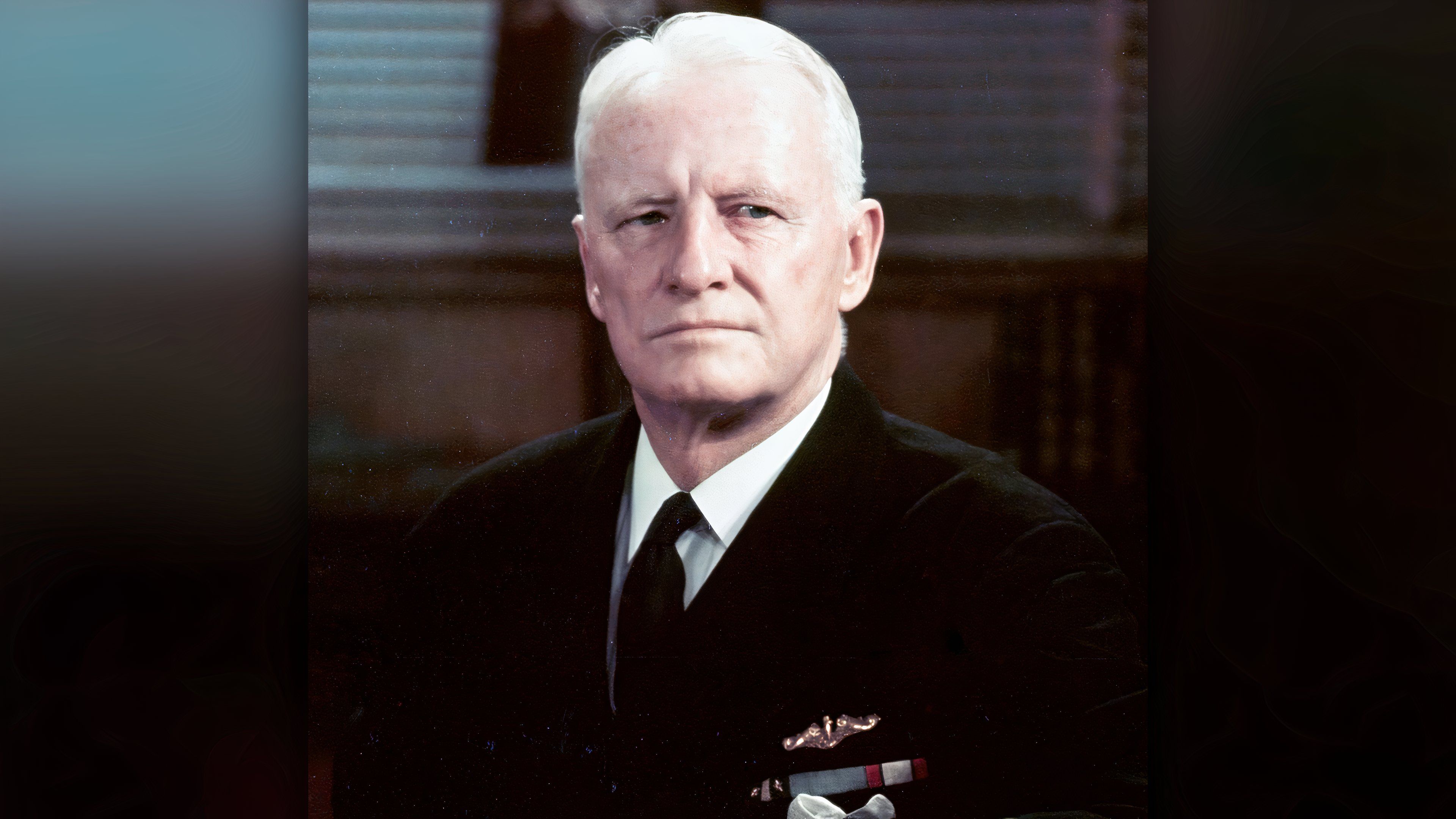 Fleet Adm. Chester W. Nimitz sits at a desk in his dark Navy uniform while serving as chief of naval operations.